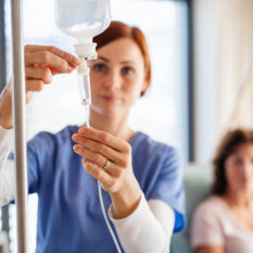 A female healthcare staff adjusting a dextrose