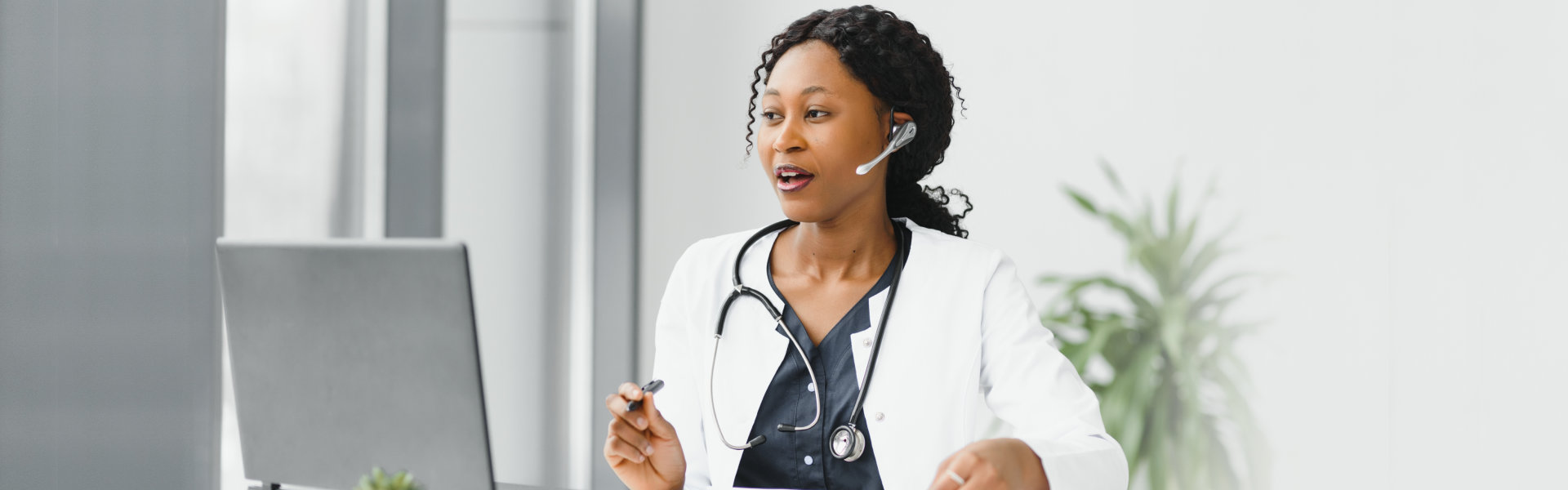 A female doctor wearing a headphone and looking at to a computer